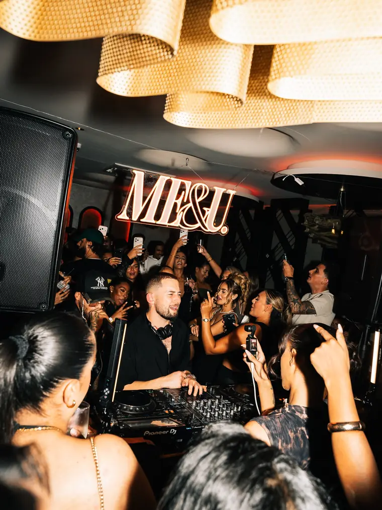 The crowd dancing in front of the DJ booth